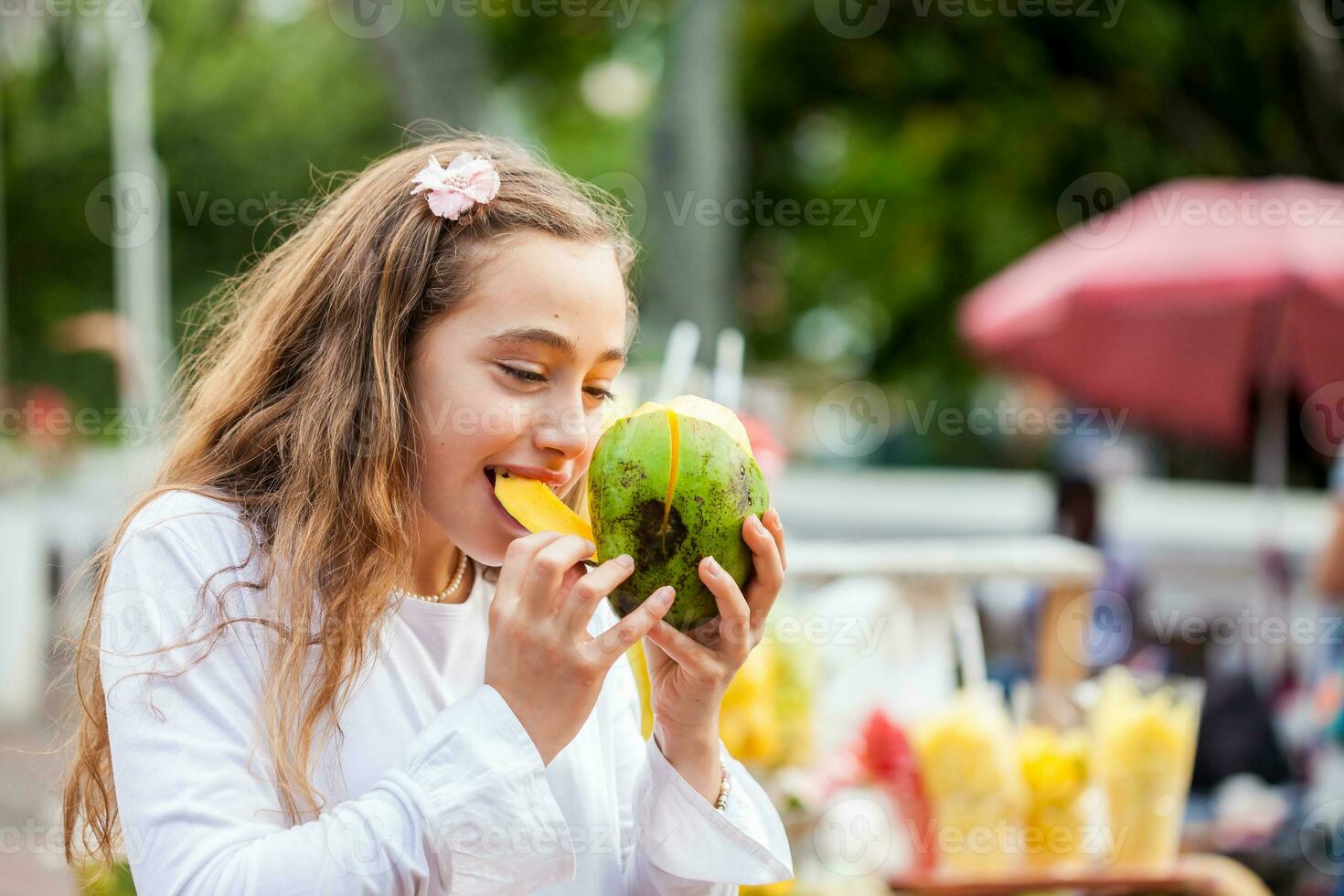 bellissimo giovane ragazza a paseo bolivar piazza nel il città di cali mangiare tropicale frutta nel Colombia foto