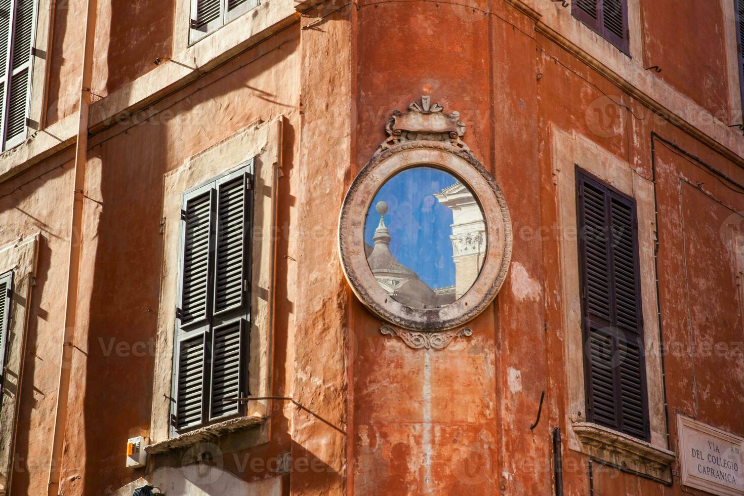 un piccolo pezzo di il Santa maria nel aquiro Chiesa riflessa su un' specchio a un' angolo di piazza capranica foto