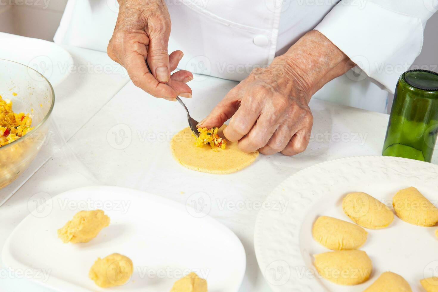 preparazione di il tradizionale tortini a partire dal il regione di cauca nel Colombia, chiamato empanadas de pipian - anziano donna Riempimento il tortini foto
