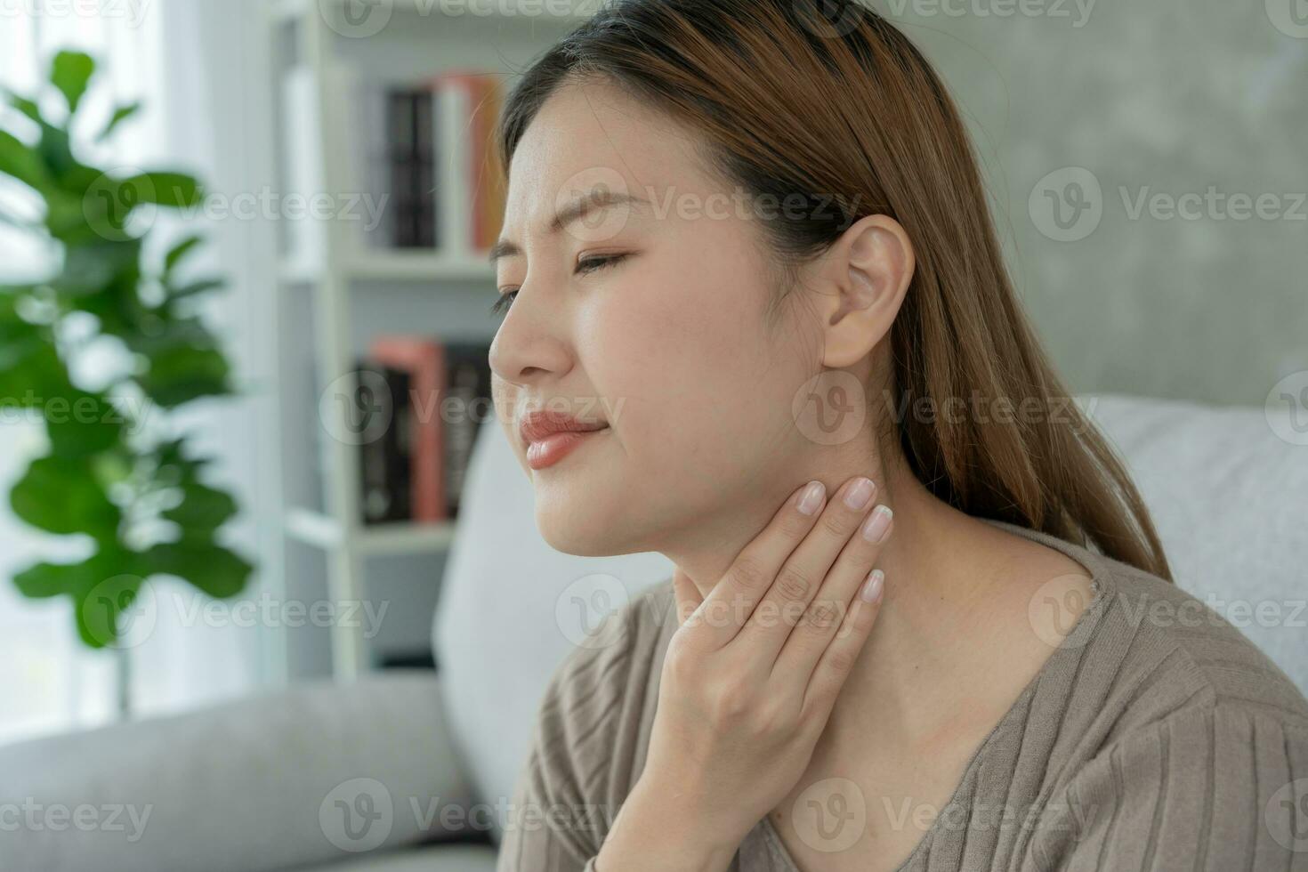 aisa donna mettere sua mano su sua collo dovuto per un' dolorante gola. femmina tonsillite cause un' infiammazione. trattati di assunzione acqua, assunzione antibiotici, consultare un' medico, virus, corona virus, influenza, influenza foto