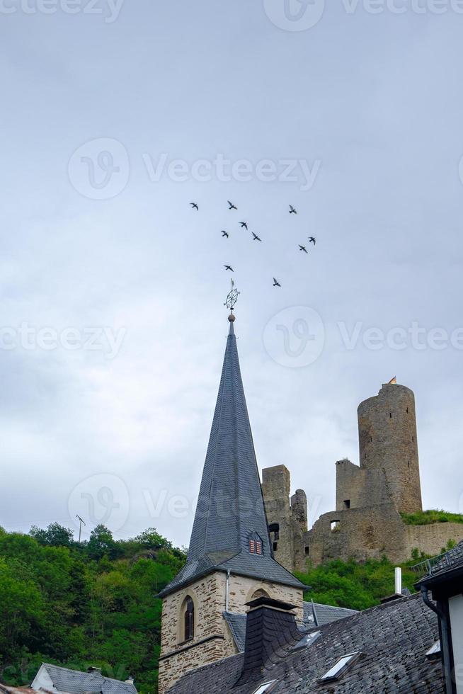 Chiesa pfarrkirche e castello di lowenburg nella pittoresca monreal, regione di eifel, germania foto