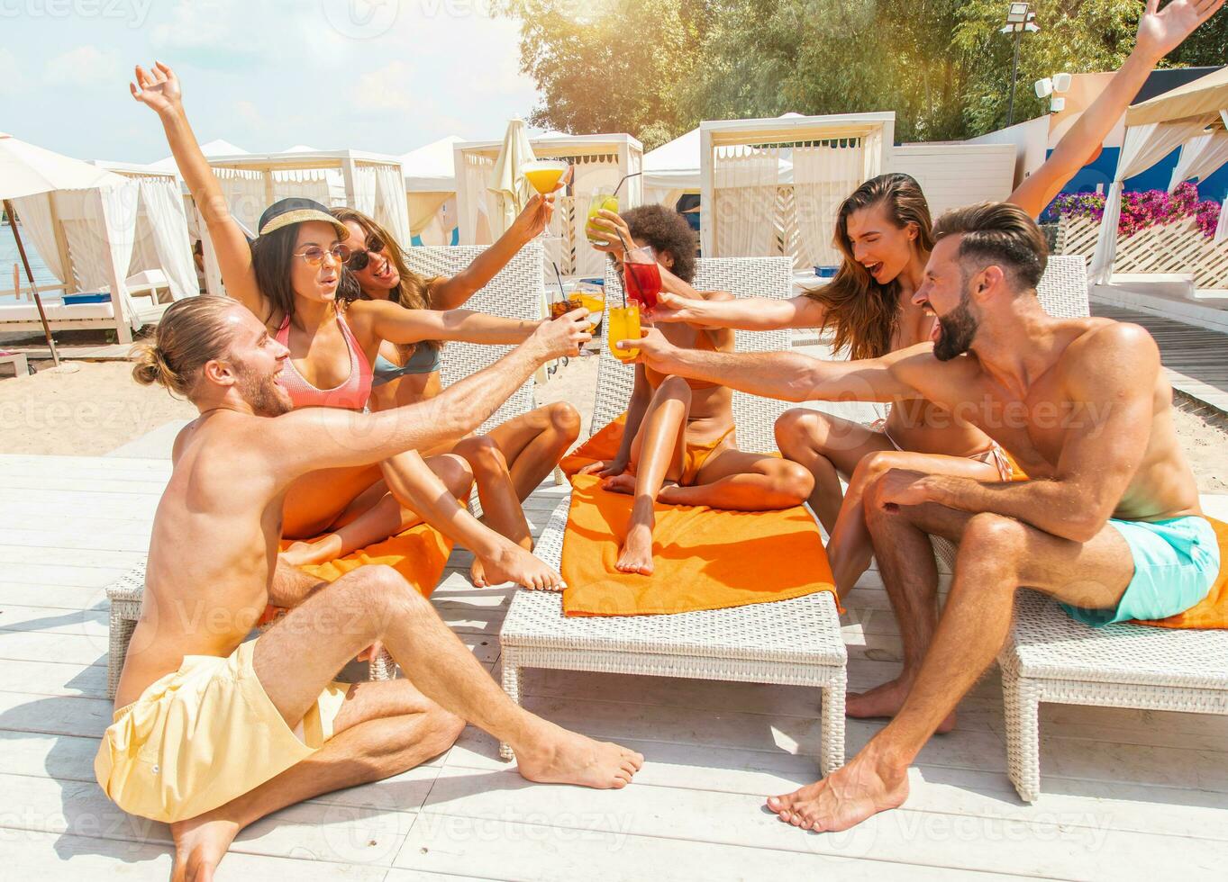 gruppo di amici con costume da bagno bevanda un' cocktail nel un' spiaggia posto foto