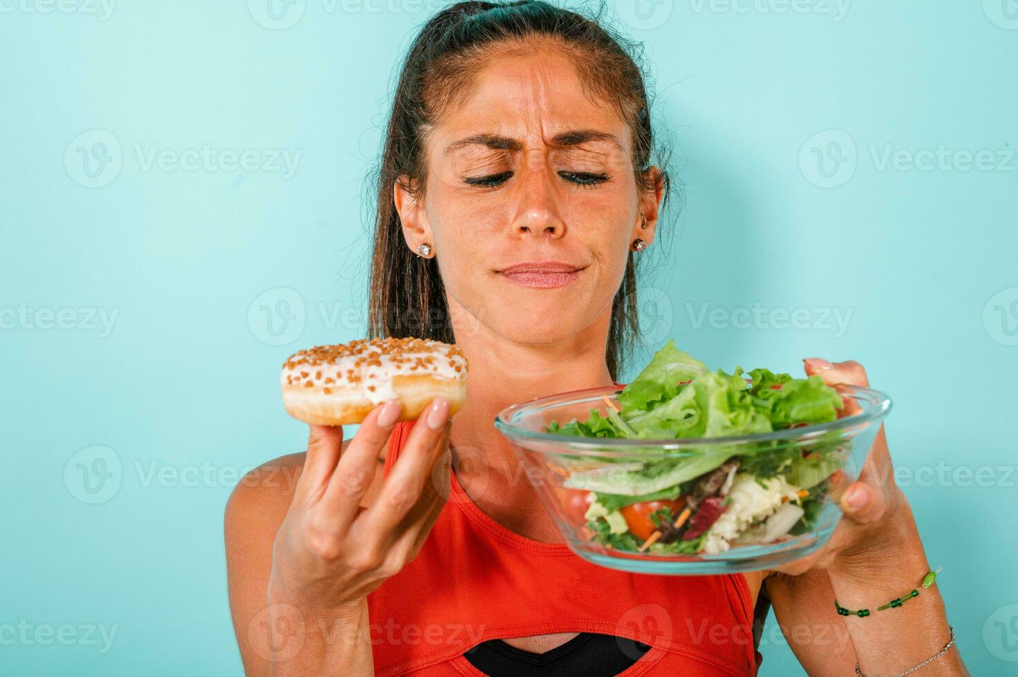 donna pensa per mangiare ciambelle anziché di un' insalata foto