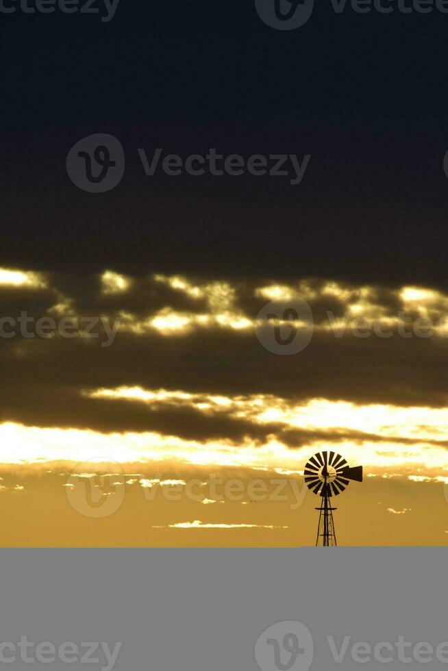 paesaggio con mulino a vento a tramonto, pampa, Patagonia, Argentina foto