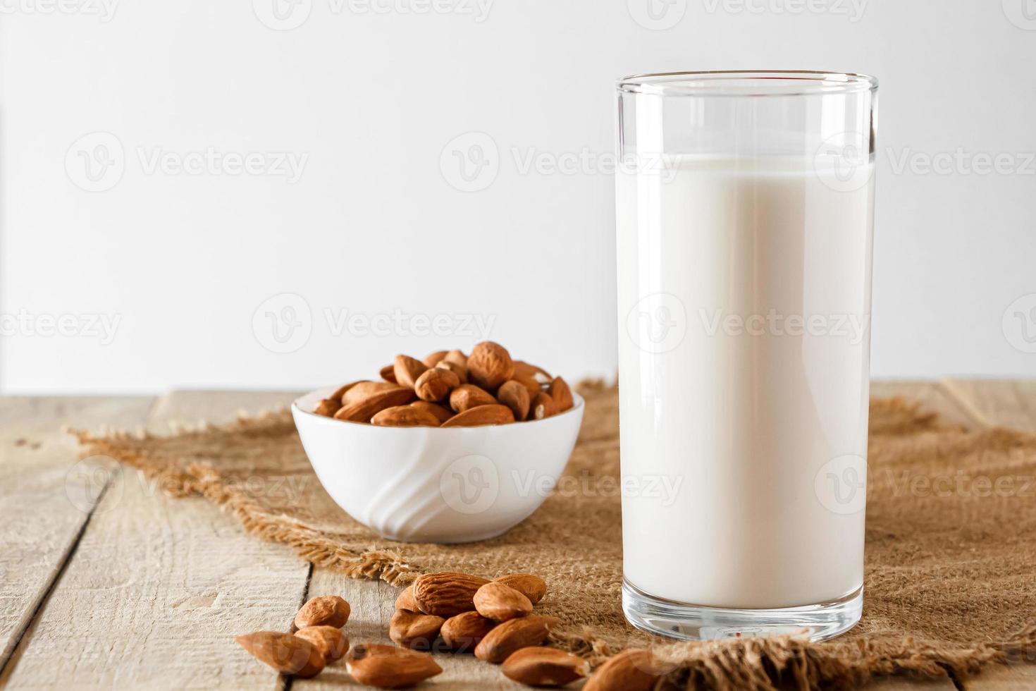 super food - un bicchiere di latte di mandorla per una dieta sana. cibo di tendenza, foto verticale. posto per il tuo testo.