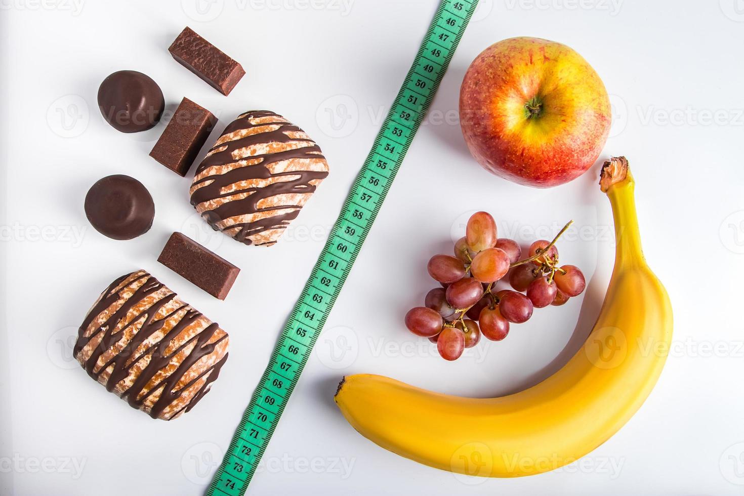 il concetto di scelta tra dieta e cibo malsano. frutta fresca o dolci. foto