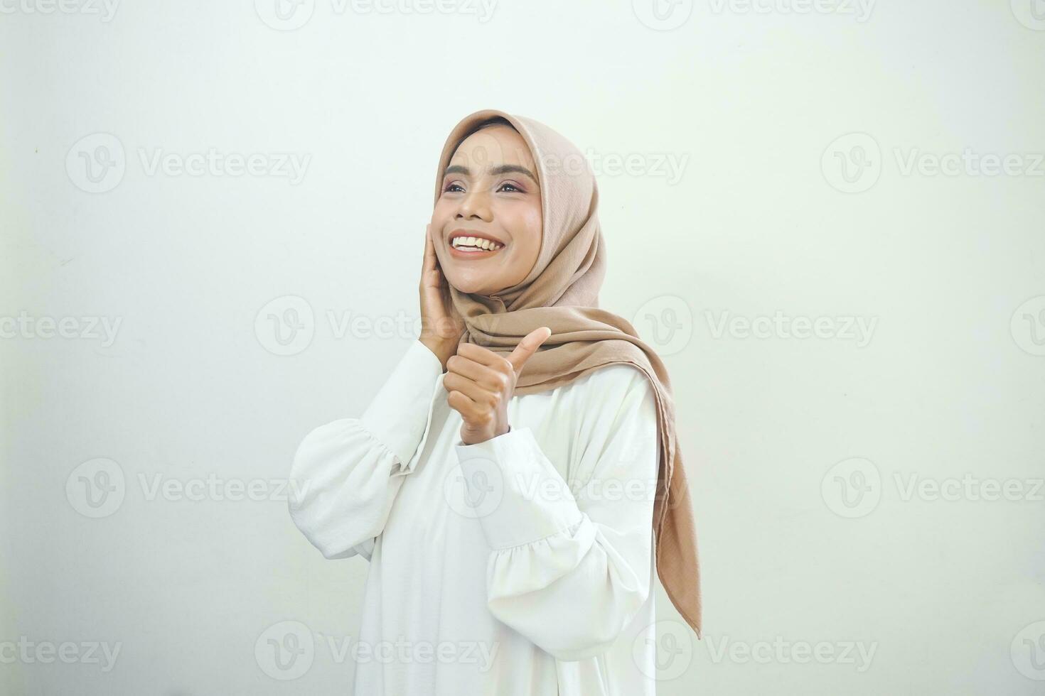 bellissimo sorridente asiatico donna nel bianca casuale mostrando pollici su gesto con mano isolato al di sopra di bianca sfondo foto