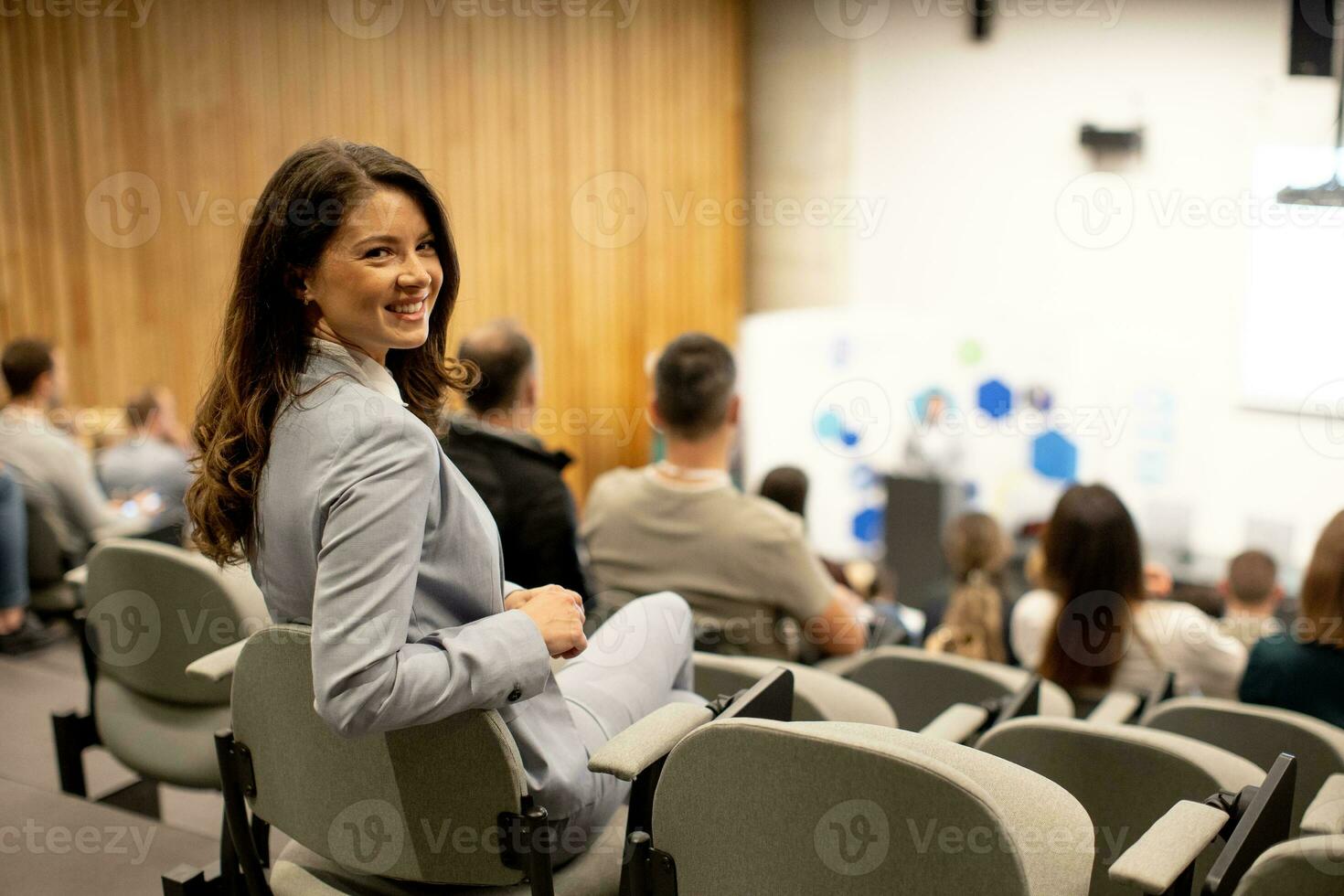 giovane donna seduta nel pubblico su conferenza o laboratorio foto