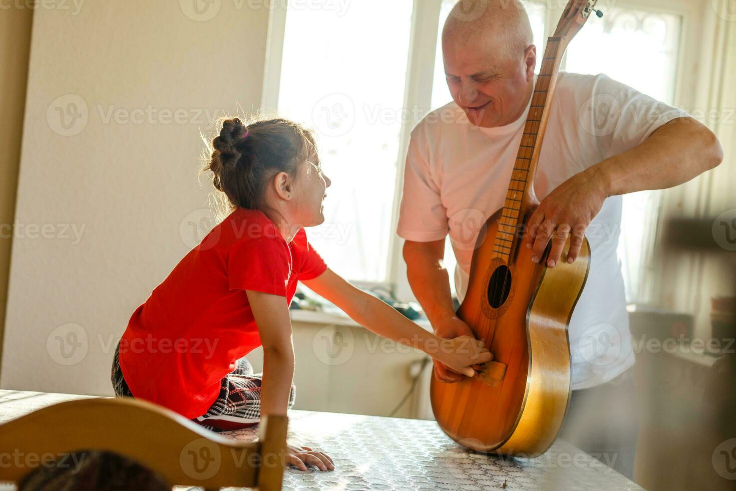 avvicinamento dell'uomo mano mutevole stringhe su il suo vecchio acustico chitarra. foto