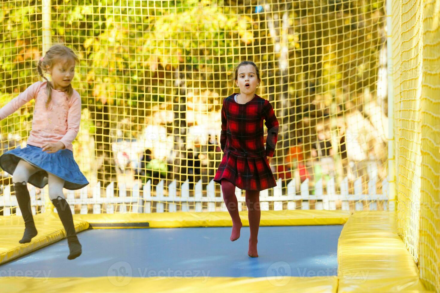 poco ragazze avendo divertimento come essi saltare su trampolino foto