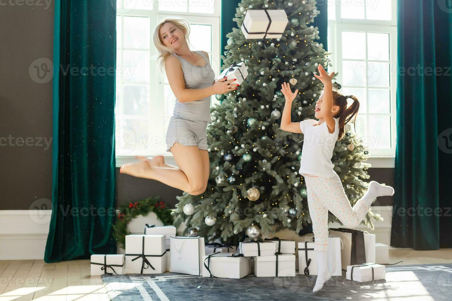 contento famiglia madre e bambino ragazza vicino un' Natale albero con Natale presente foto