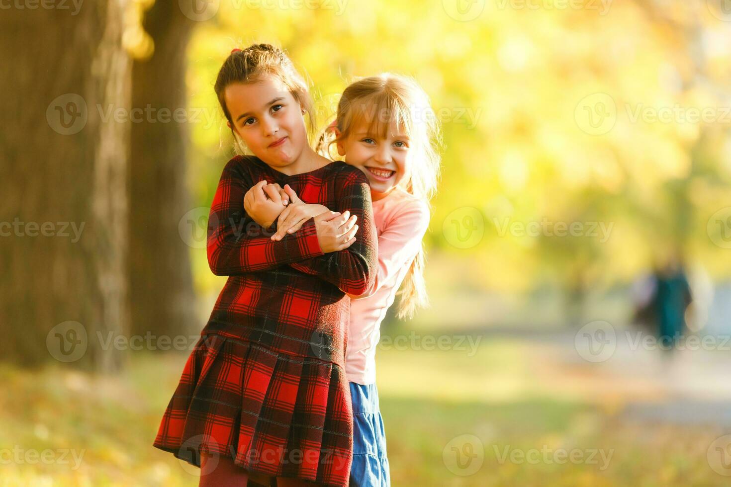 Due poco ragazze nel autunno parco foto