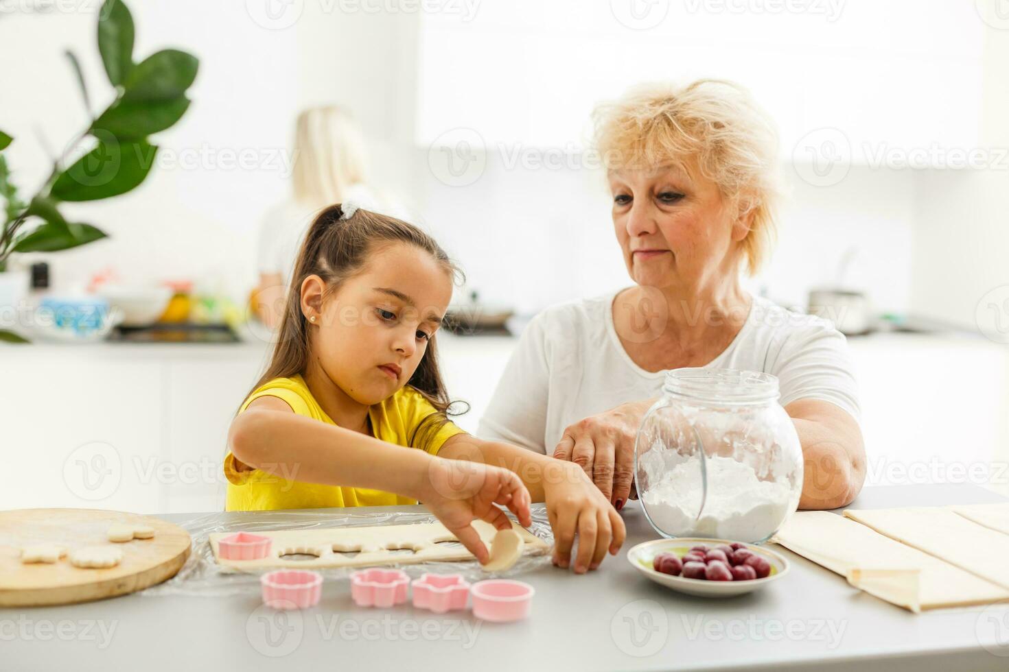 carino poco ragazza e sua nonna cucinando su cucina. foto