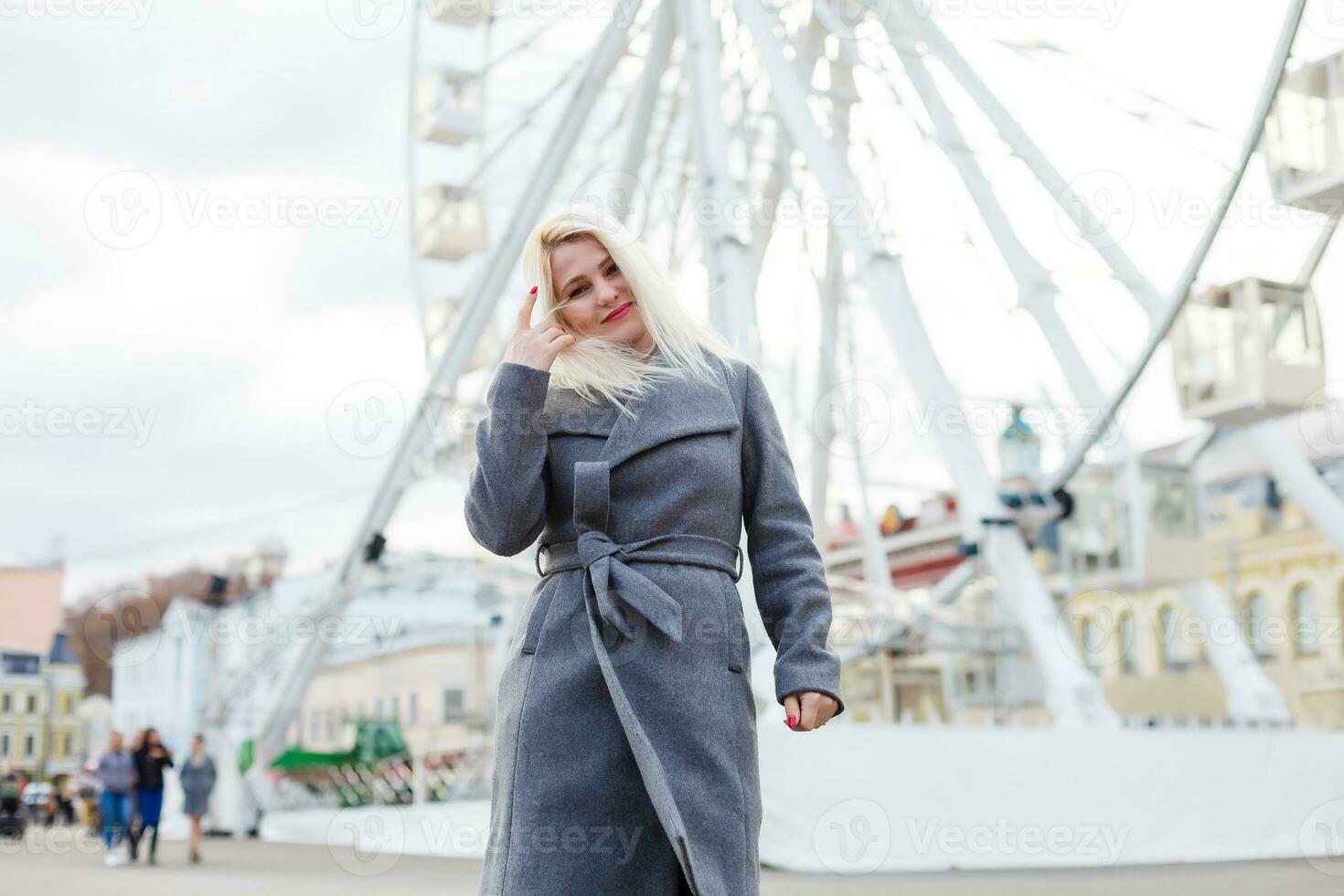 elegante donna in posa vicino Ferris ruota foto