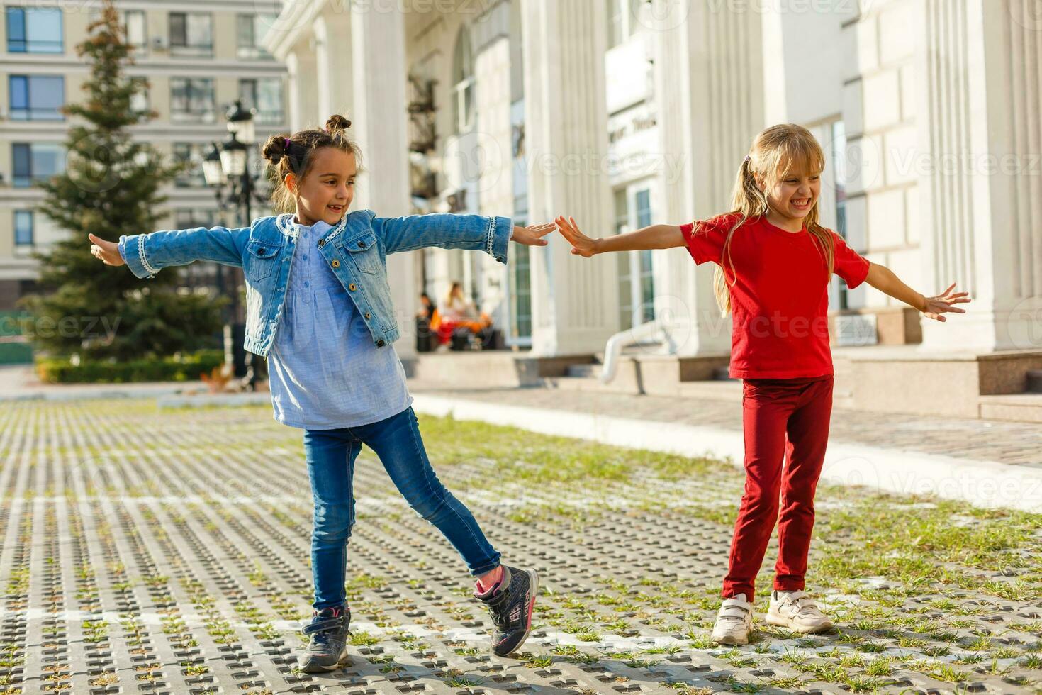 ritratto di contento moda poco ragazze avendo divertimento nel il città foto