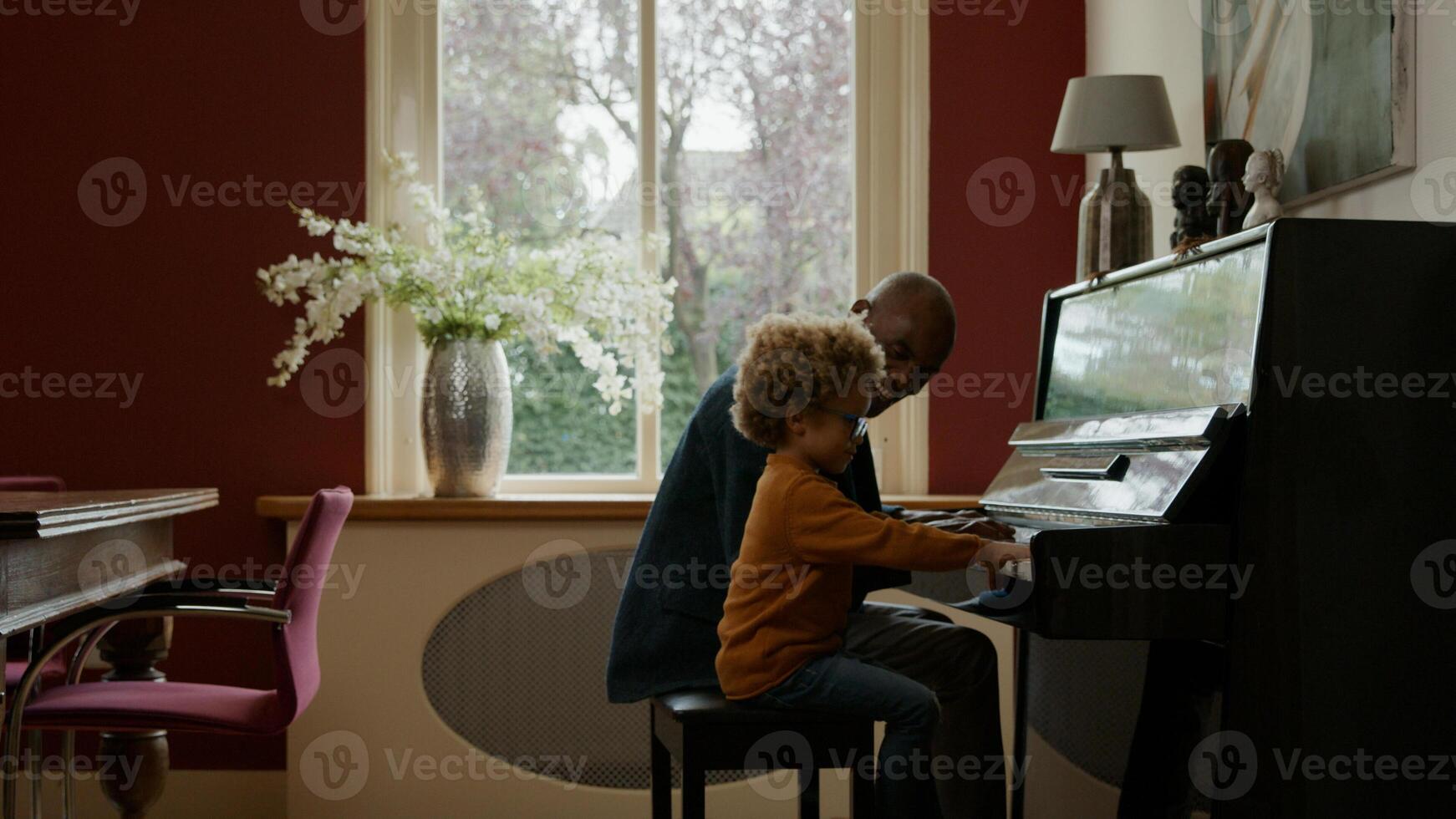 uomo maturo insegnamento al nipote pianoforte foto