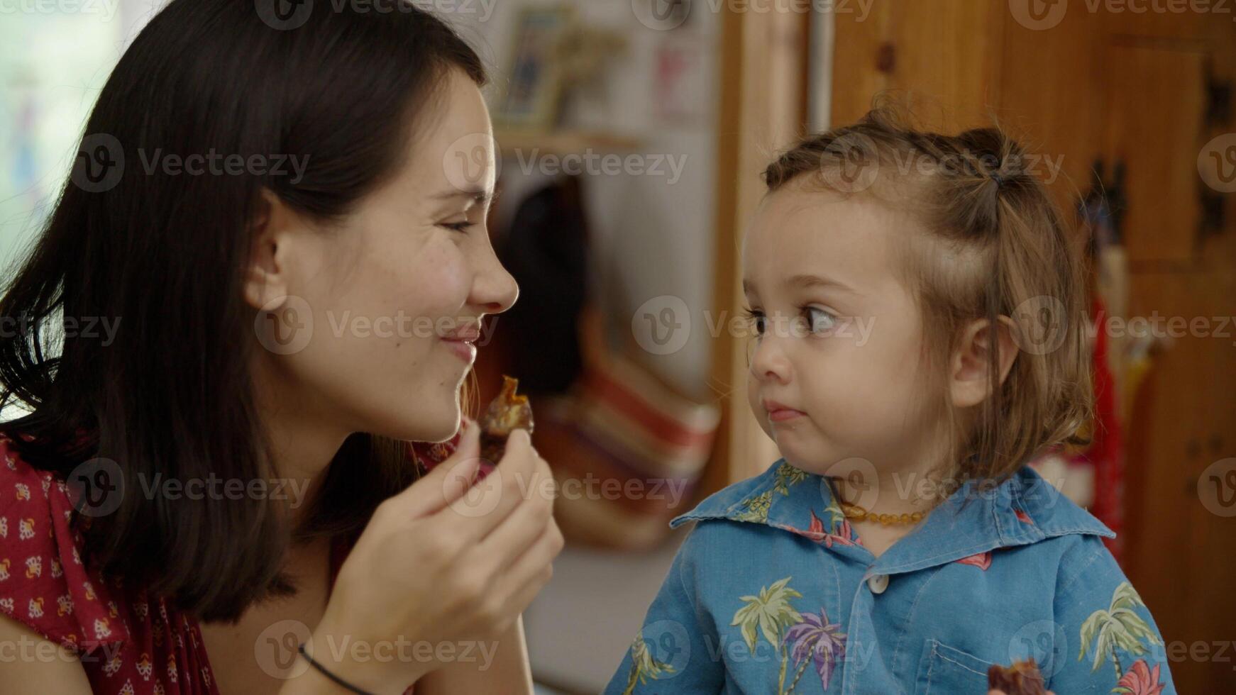 ritratto della madre che mangia uno spuntino con la figlia foto