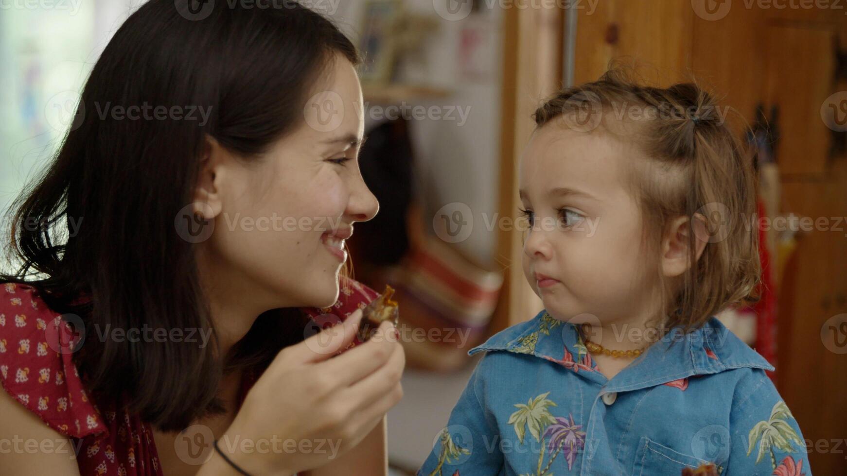 ritratto della madre che mangia uno spuntino con la figlia foto