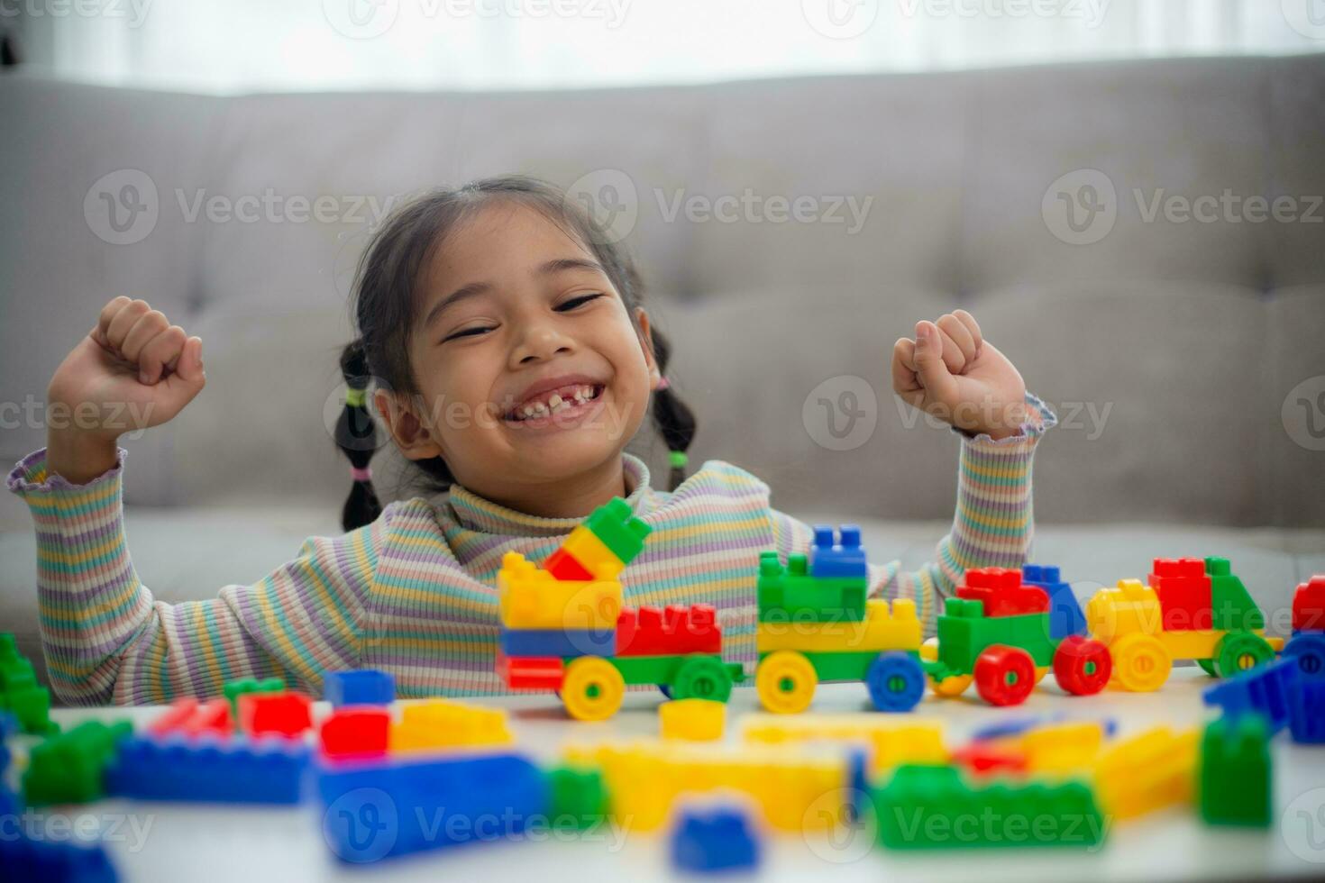 adorabile bambina che gioca a blocchi giocattolo in una stanza luminosa foto