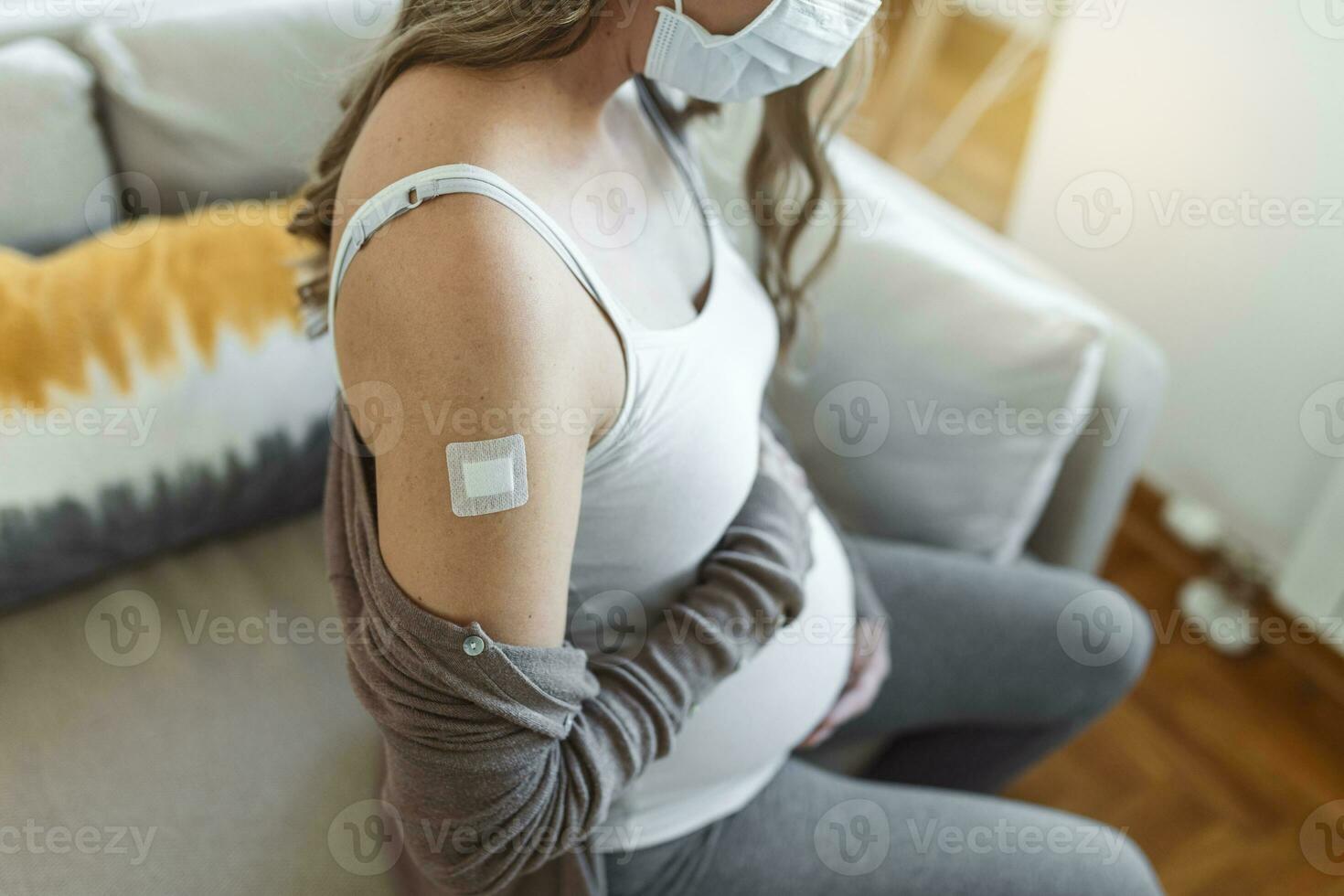 incinta donna con adesivo bendare su sua braccio dopo corona virus vaccino. primo aiuto. medico, farmacia e assistenza sanitaria concetto. foto