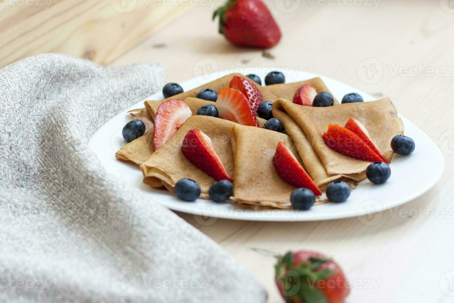 Pancakes con mirtilli e fragole su il tavolo. tradizionale cibo per maslenitsa foto