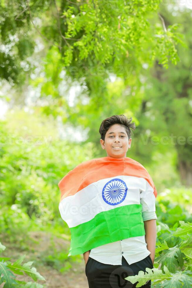 indiano ragazzo Tenere nazionale bandiera nel azienda agricola, contento ragazzo, nazionale bandiera foto