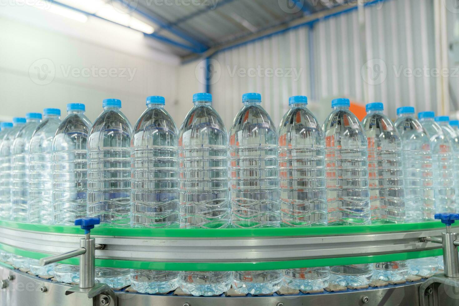 acqua fabbrica - acqua imbottigliamento linea per in lavorazione e imbottigliamento puro minerale acqua in blu bottiglie. selettivo messa a fuoco. foto
