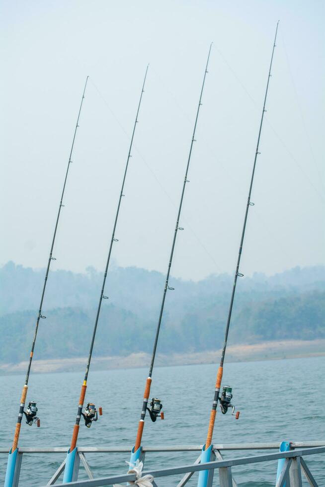 tre pesca canne nel il fiume foto