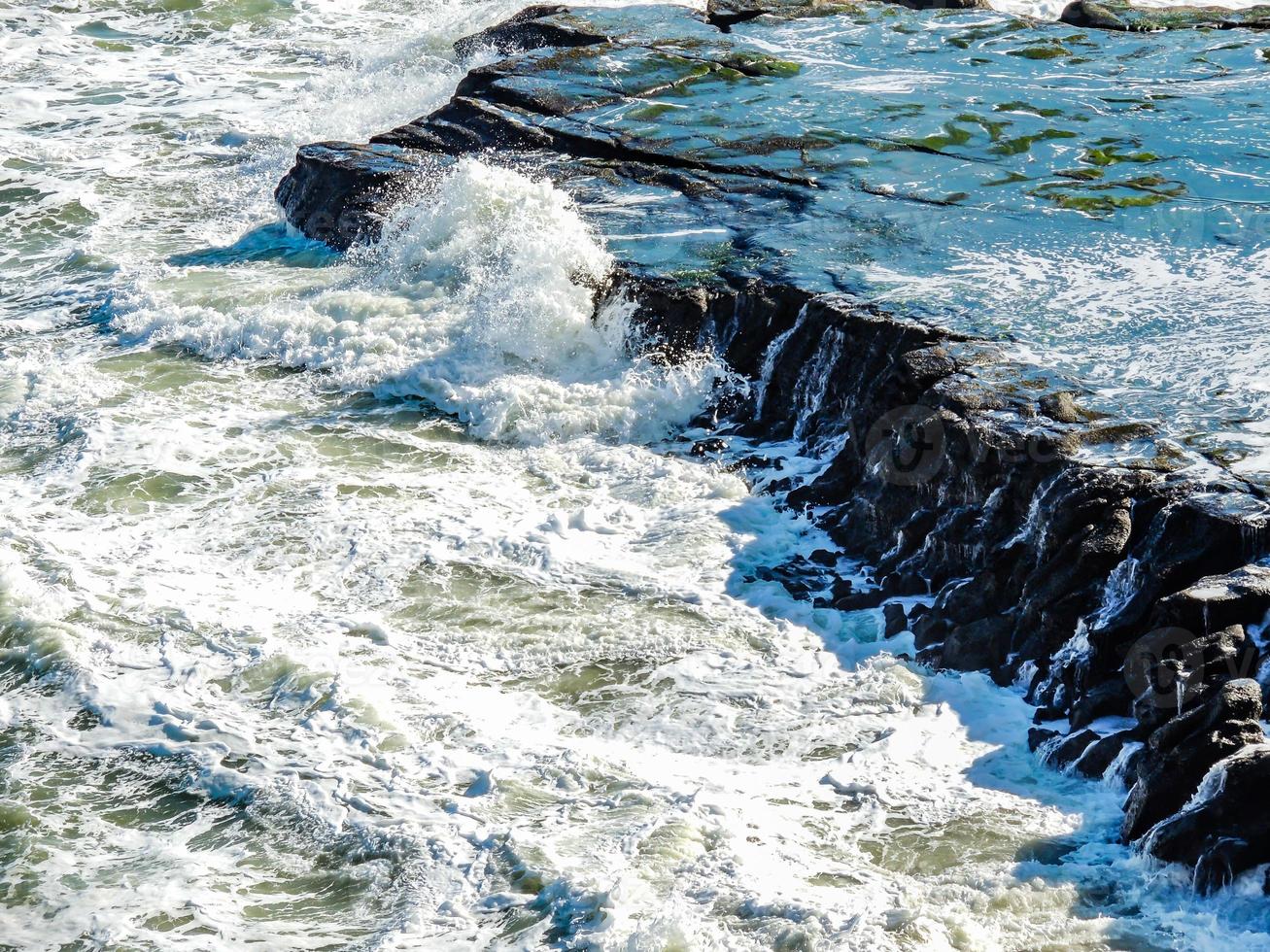 le onde si infrangono sulla spiaggia di muriwai, auckland, in nuova zelanda foto