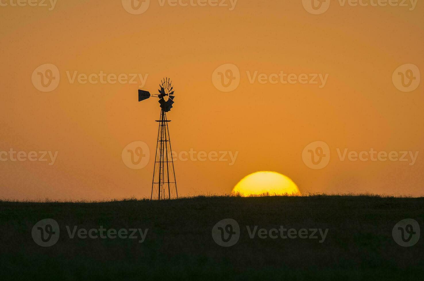 un' mulino a vento e un' sole ambientazione nel il distanza foto