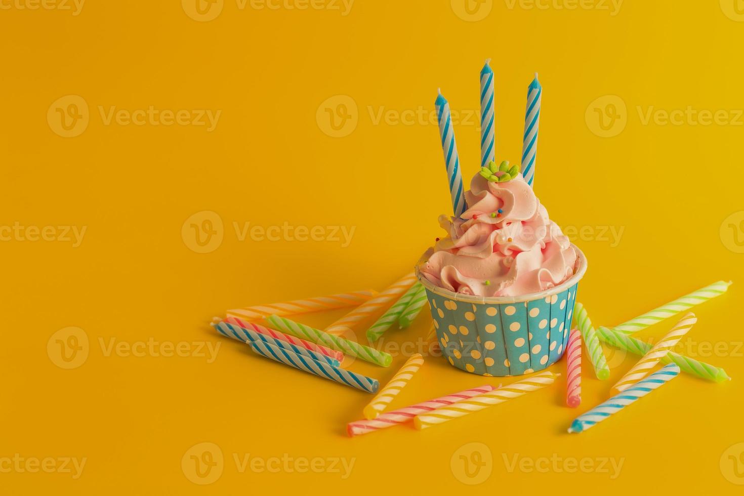 gustoso cupcake di compleanno con candele su sfondo di colore giallo foto