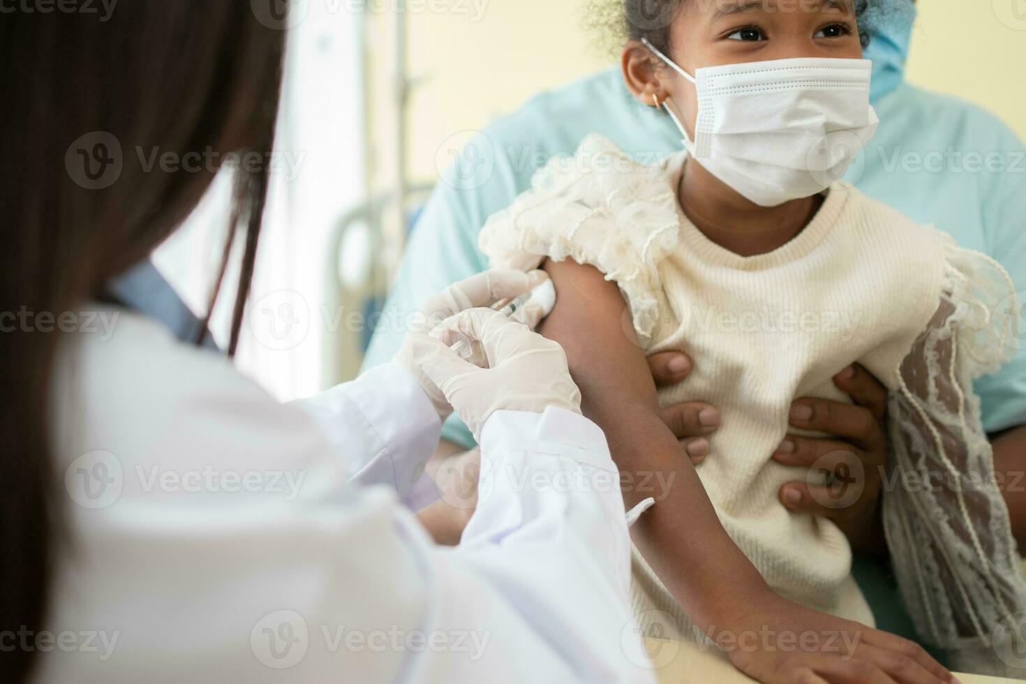 asiatico medico utente siringa ago per iniezione vaccinare, africano americano bambini siamo essere covid vaccinati per prevenzione coronavirus e influenza. concetto di immunizzazione a partire dal inoculazione foto