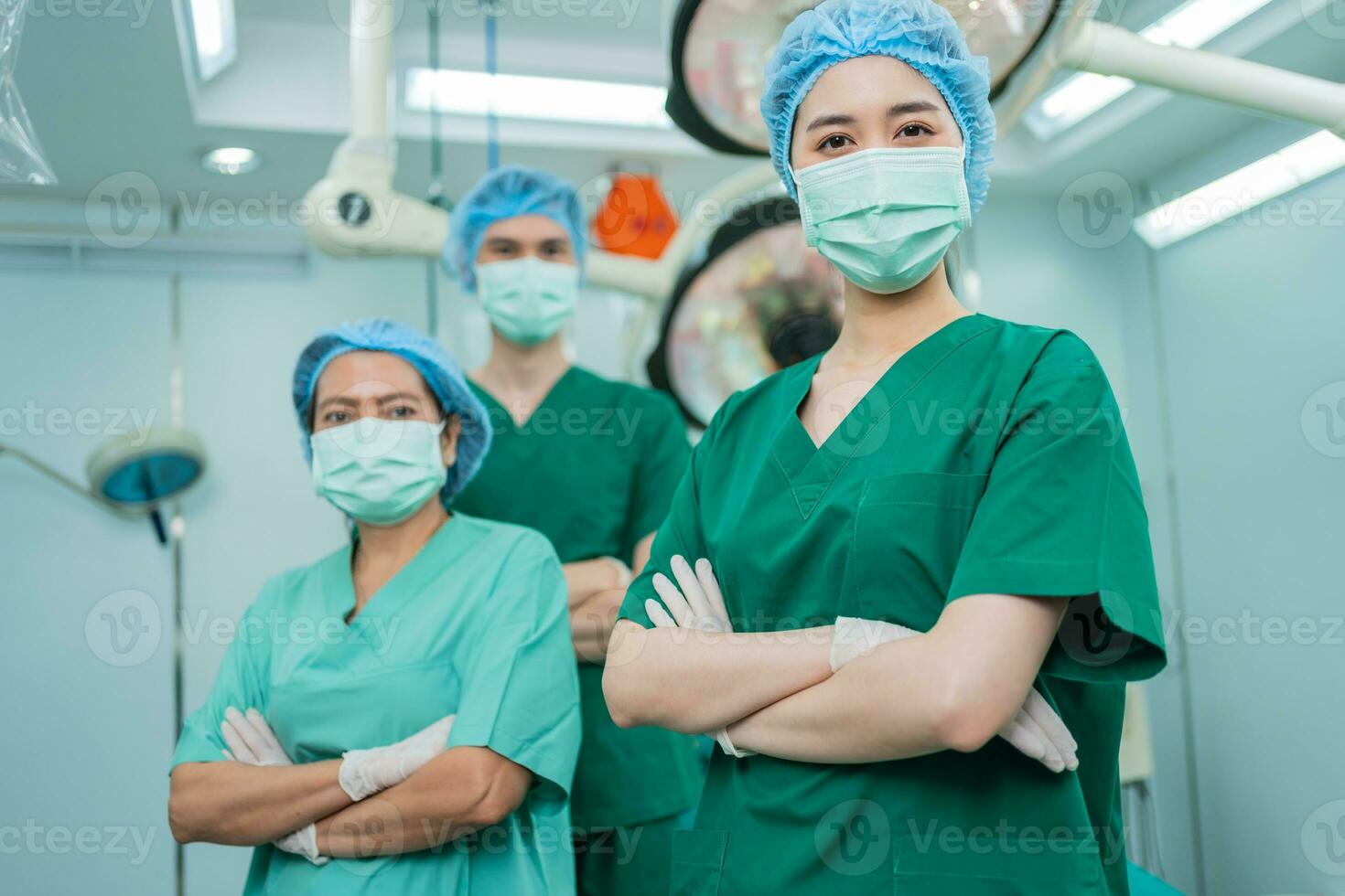 ritratto di asiatico donne chirurgo e infermiera con medico maschera in piedi con braccia attraversato nel operazione Teatro a un' Ospedale. squadra di professionale chirurghi. assistenza sanitaria, emergenza medico servizio concetto foto