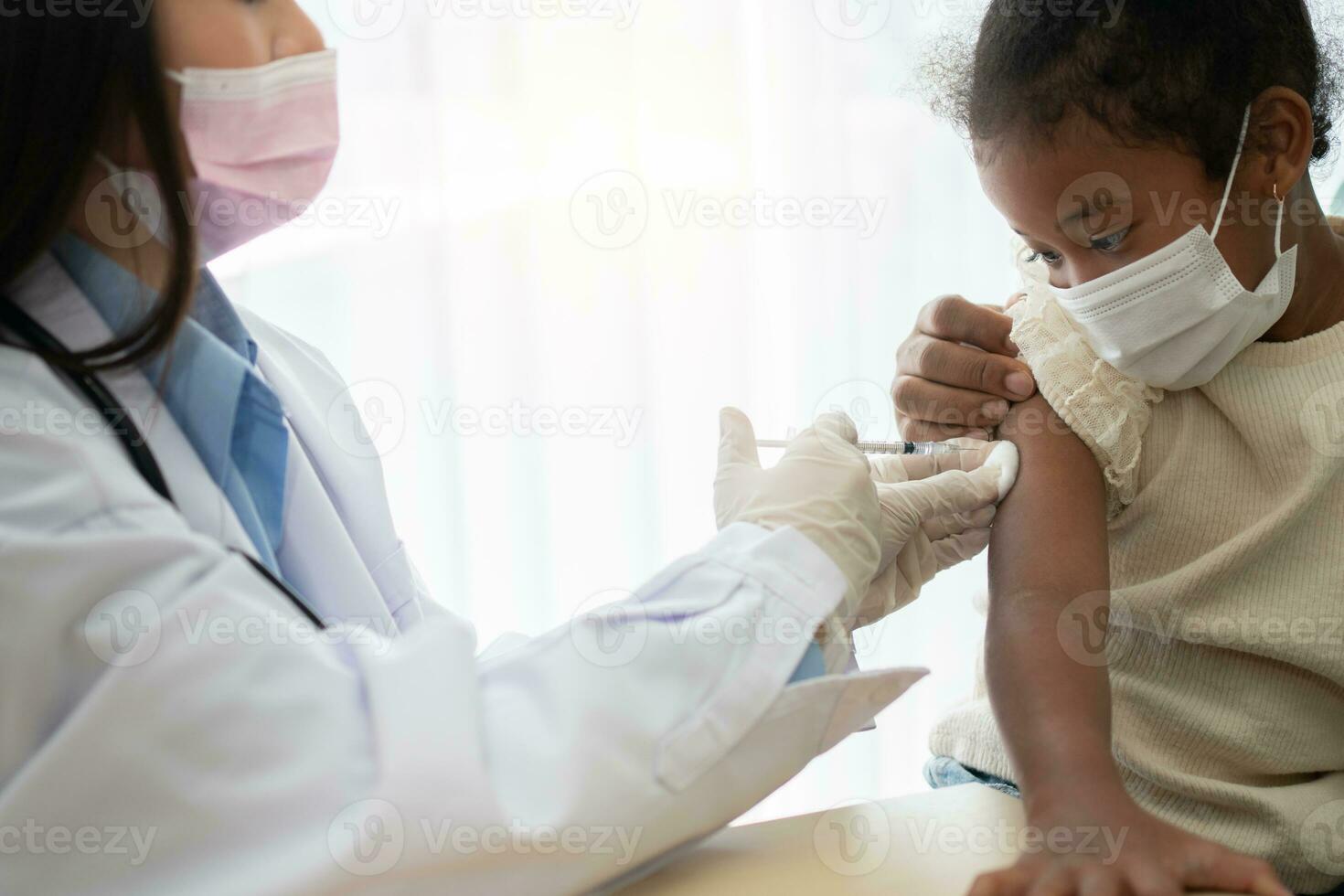 asiatico medico utente siringa ago per iniezione vaccinare, africano americano bambini siamo essere covid vaccinati per prevenzione coronavirus e influenza. concetto di immunizzazione a partire dal inoculazione foto