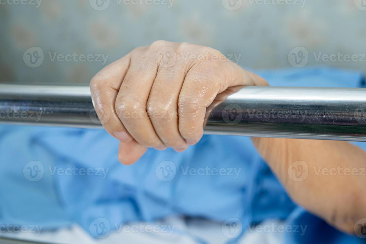 asiatico anziano o anziana paziente sdraiata maneggiare il letto ferroviario con speranza su un letto in ospedale. foto