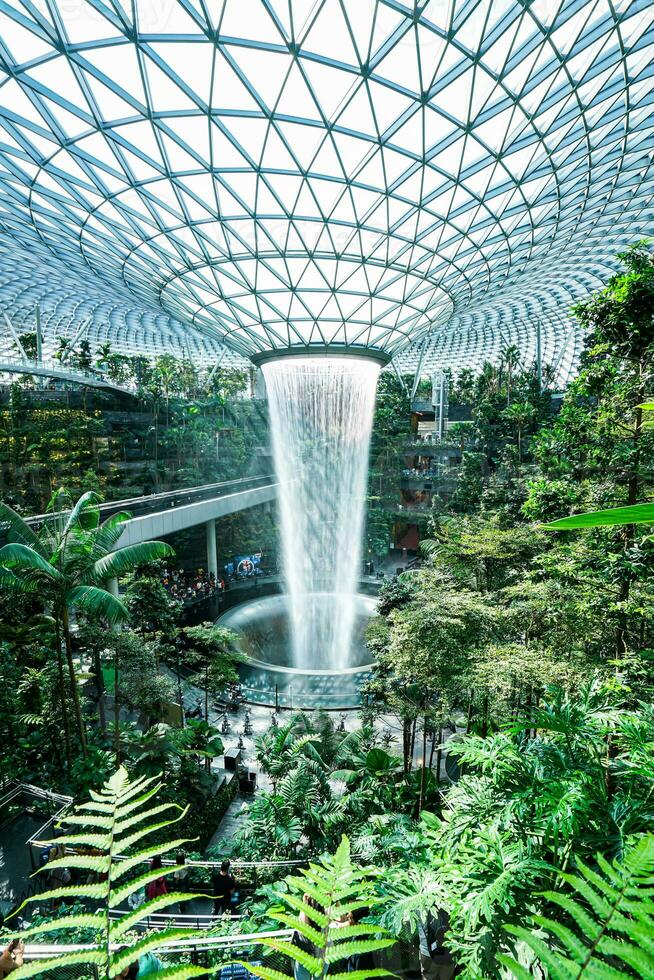 il pioggia vortice, quale il gioiello chiamate un altro evidenziare di di singapore changi aeroporto, è il maggiore e il più alto interno cascata nel il mondo a 130 piedi alto. foto