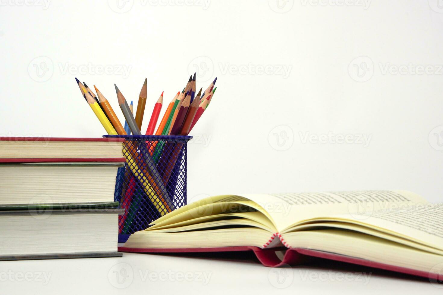 pastello o colorato matite nel scatola e il libro posto nel il sfocato sfondo. conoscenza e formazione scolastica concetto. foto