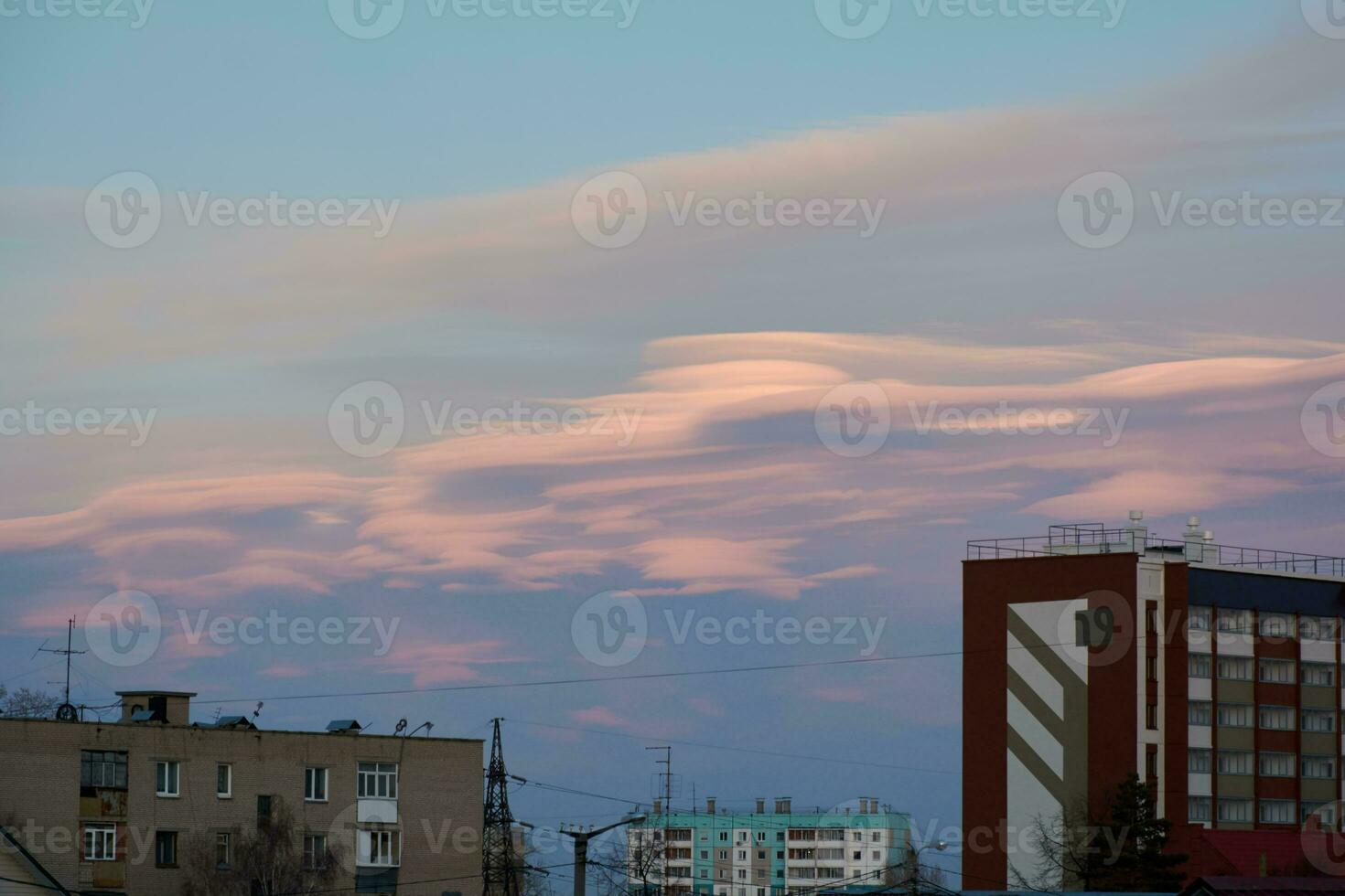 lenticolare nuvole nel il città sopra il tetti di grattacielo edifici a tramonto. bellissimo cielo foto