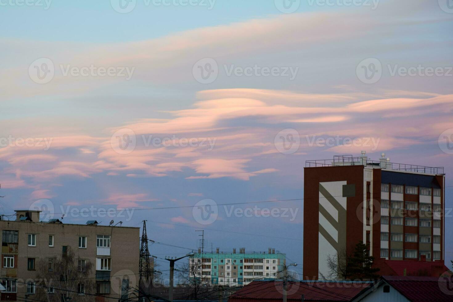 lenticolare nuvole nel il città sopra il tetti di grattacielo edifici a tramonto. bellissimo cielo foto