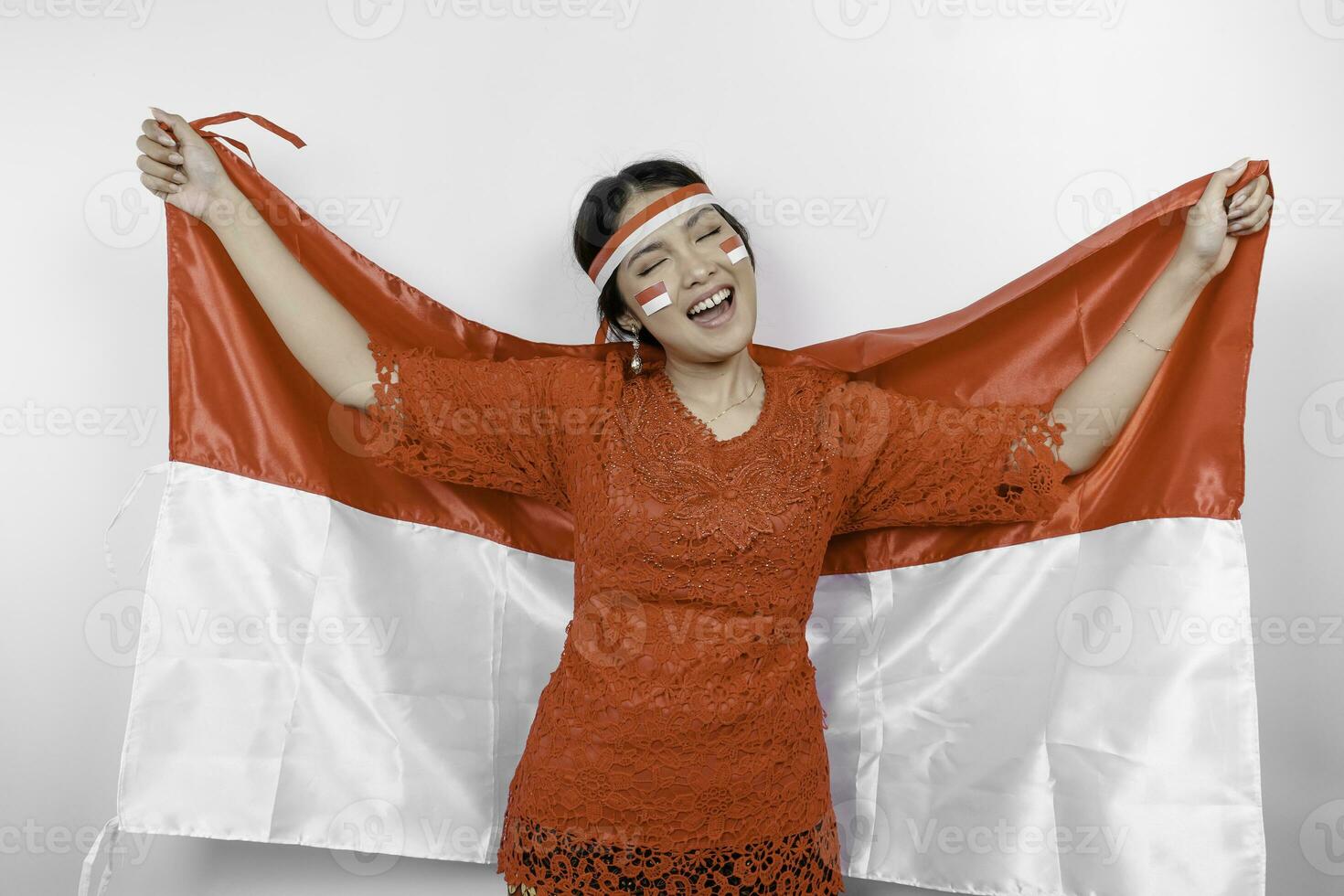 contento sorridente indonesiano donna indossare rosso kebaya e fascia per capelli Tenere dell'Indonesia bandiera per celebrare Indonesia indipendenza giorno isolato al di sopra di bianca sfondo. foto