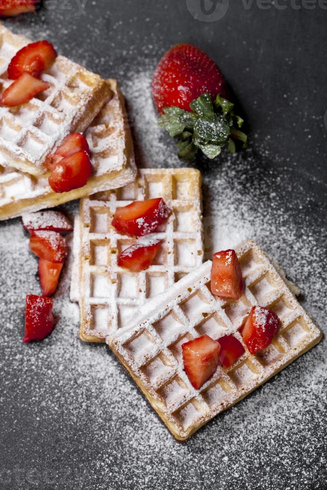 belgio waffer con fragole e zucchero in polvere su lavagna. foto