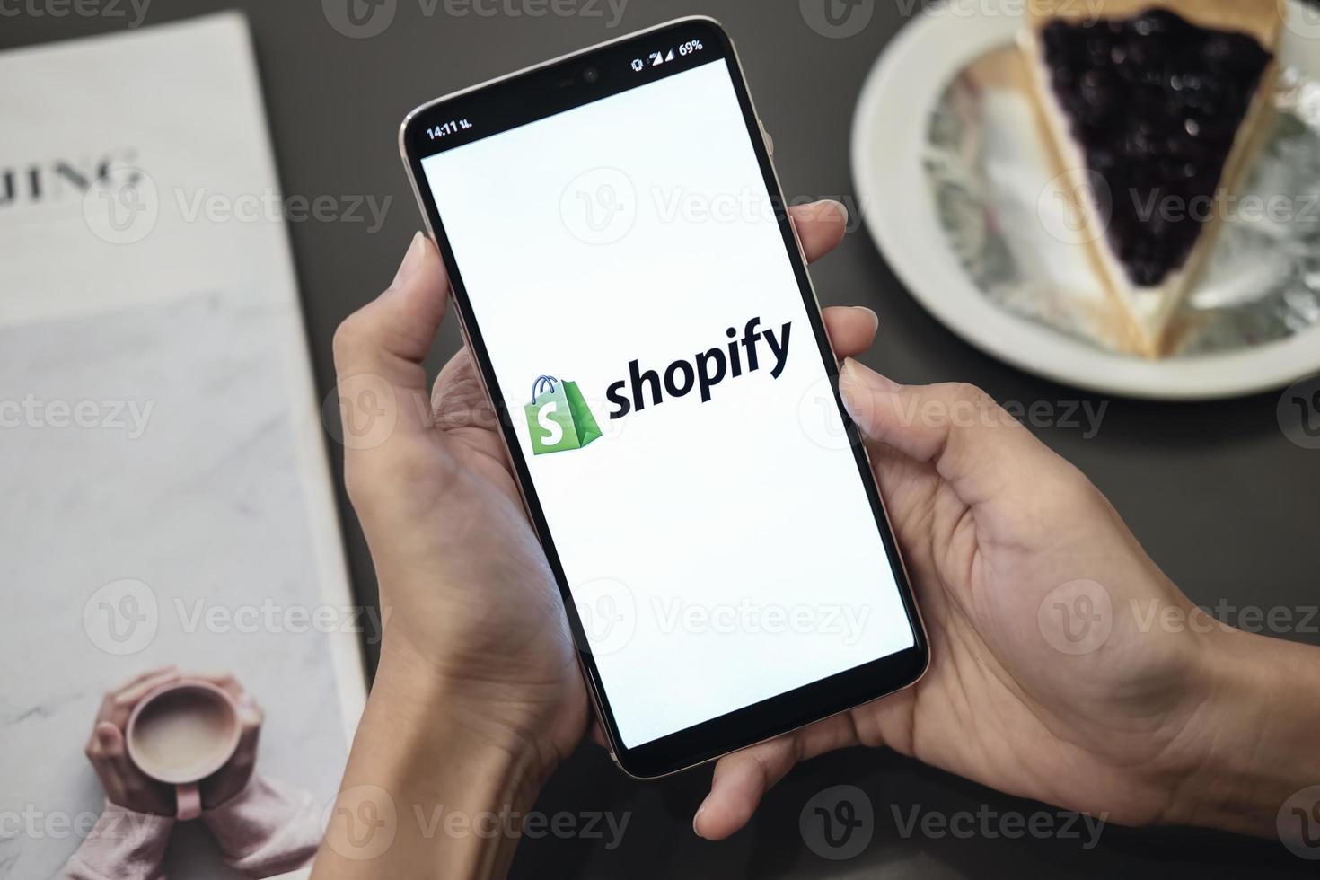 chiang mai, thailandia 2019- donna che tiene in mano uno smartphone che mostra l'applicazione shopify sul cellulare foto