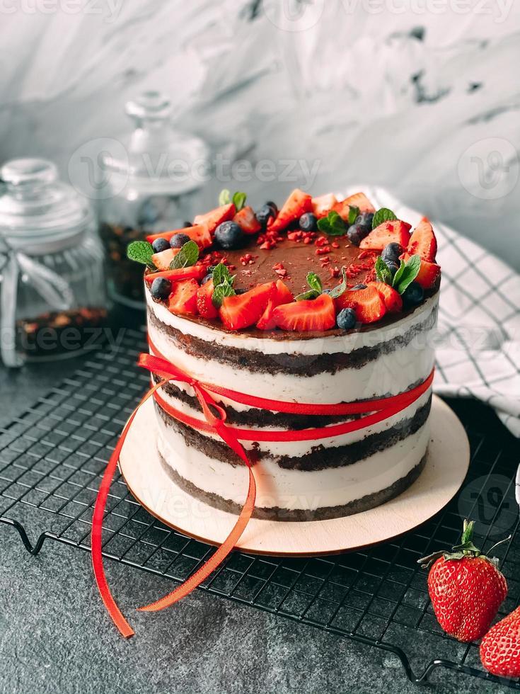 torta deliziosa e succosa fatta in casa decorata con fragole e frutti di bosco vivi. foto