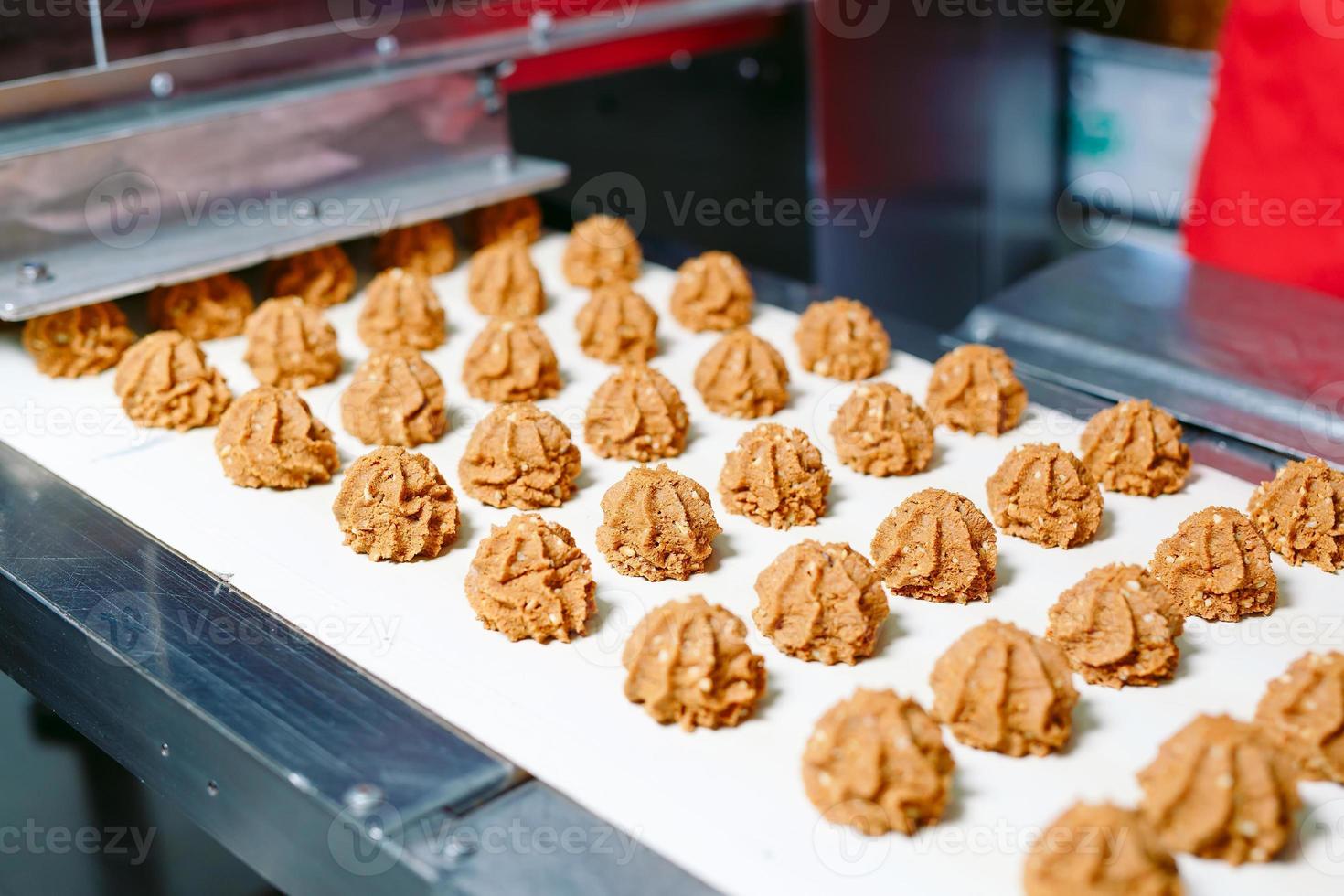 produzione di dolci e concetto di industria - lavorazione di cioccolatini su nastro trasportatore in pasticceria. foto