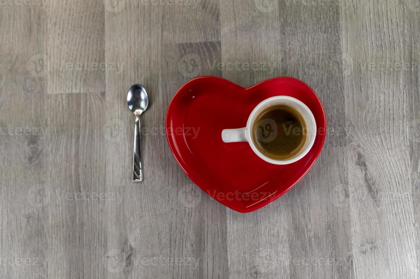 una tazza di caffè con un piattino a forma di cuore foto