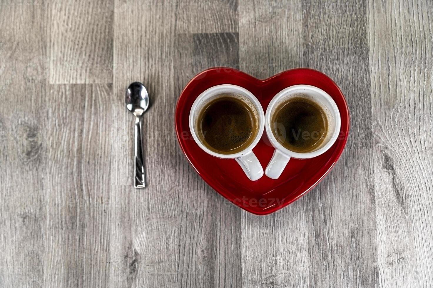 due tazzine di caffè con piattino a cuore foto