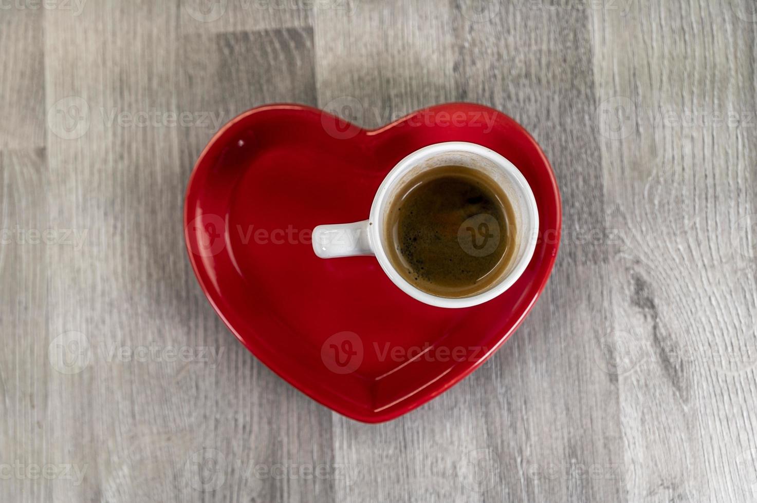 una tazza di caffè con un piattino a forma di cuore foto