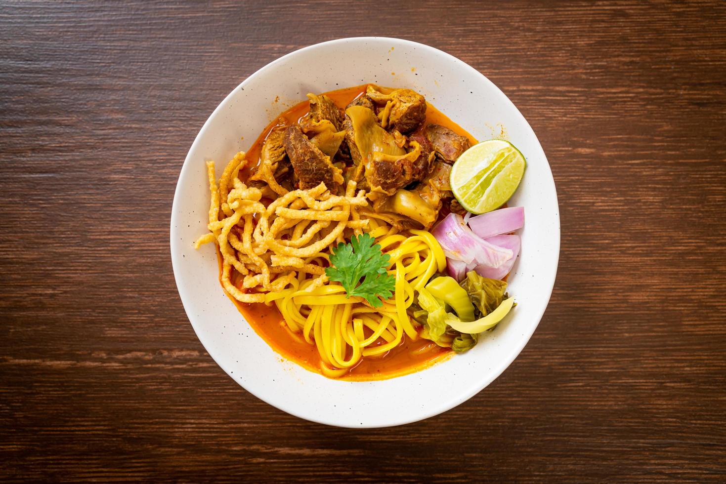 zuppa di noodle al curry del nord della Thailandia con maiale brasato foto