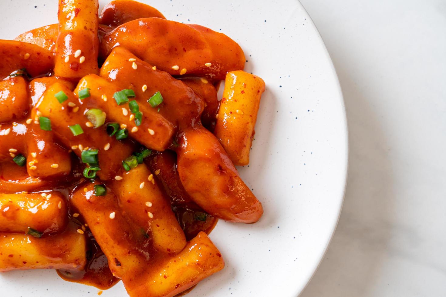 Stecco di torta di riso coreano con salsiccia in salsa piccante - tteokbokki foto