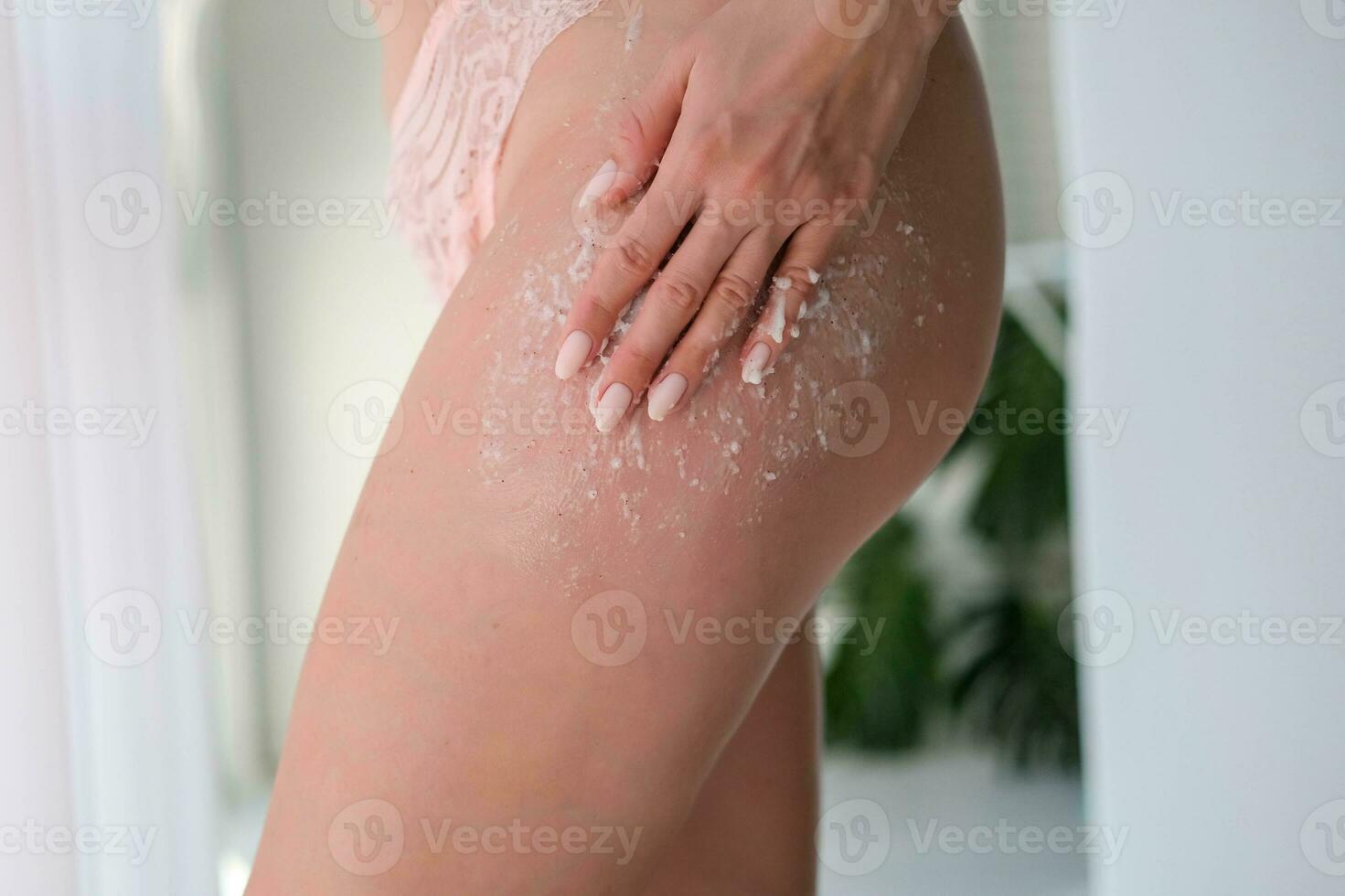 un' donna si applica macchia su sua gambe. donne uso anticellulite crema. femmina corpo cura. cosmetologia, massaggio, terme cosmetici. foto